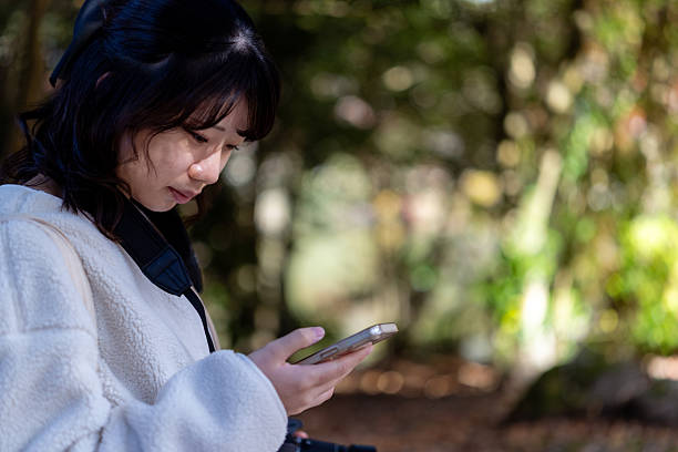 istock Young female tourist using smart phone in nature 2248544789