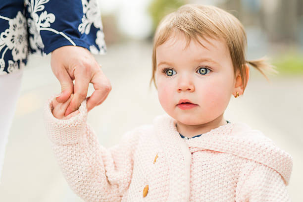 istock young girl holding hands with her parent outside 2248545345