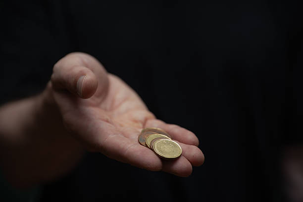 istock A Hand Holding Few Coins Offering Value 2248548088