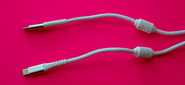 ​A striking shot of two white braided cables for charging and data transfer, one featuring a USB Type-C connector and the other a round magnetic plug.