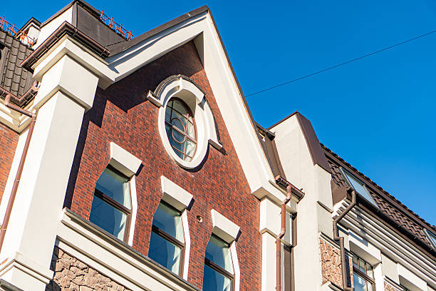 istock Ancient European city building facade, red brick with white decorative elements window frames, doorways, paneling, varying window sizes and shapes arches, semi-circles, central curved doorway, po 2248552676