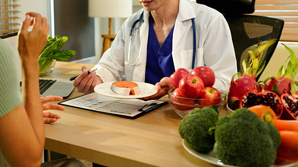 istock Dietician, male nutrition specialist consulting woman, developing healthy diet, dietary program. Dietary consultant asking, giving male patient advice, help, nutritional information, new meal plan 2248552864