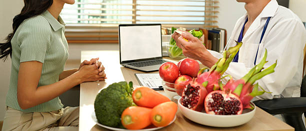 istock Dietician, male nutrition specialist consulting woman, developing healthy diet, dietary program. Dietary consultant asking, giving male patient advice, help, nutritional information, new meal plan 2248552901