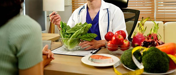 istock Dietician, male nutrition specialist consulting woman, developing healthy diet, dietary program. Dietary consultant asking, giving male patient advice, help, nutritional information, new meal plan 2248552913