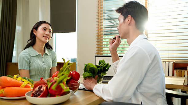 istock Dietician, male nutrition specialist consulting woman, developing healthy diet, dietary program. Dietary consultant asking, giving male patient advice, help 2248552927