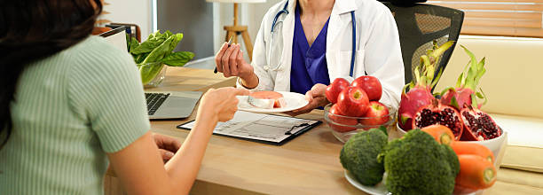 istock Dietician, male nutrition specialist consulting woman, developing healthy diet, dietary program. Dietary consultant asking, giving male patient advice, help, nutritional information, new meal plan 2248552929