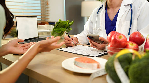 istock Dietician, male nutrition specialist consulting woman, developing healthy diet, dietary program. Dietary consultant asking, giving male patient advice, help, nutritional information, new meal plan 2248552986