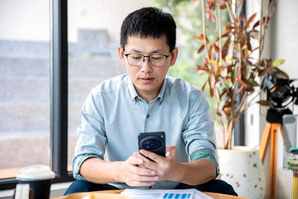 istock An Asian businessman using his mobile phone in a coffee shop 2248554236