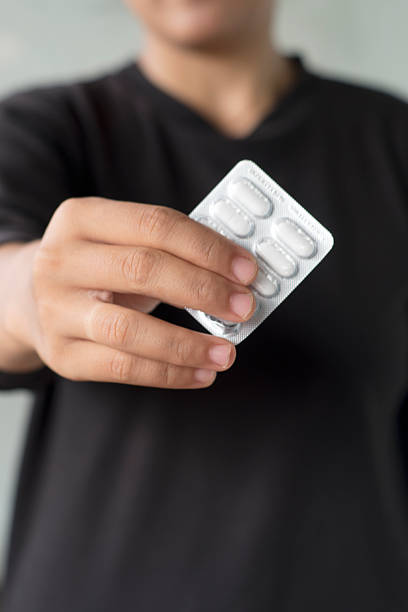 istock human Hand Holding Medicine Blister Pack on Neutral Background 2248555945