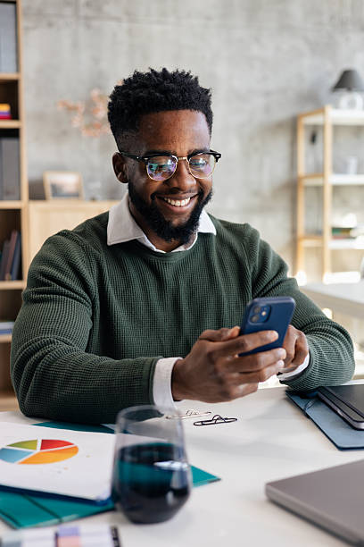 istock Smiling man working with smartphone at office desk 2248556276