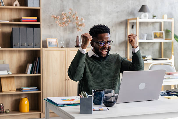 istock Excited man celebrating professional success using laptop 2248556279