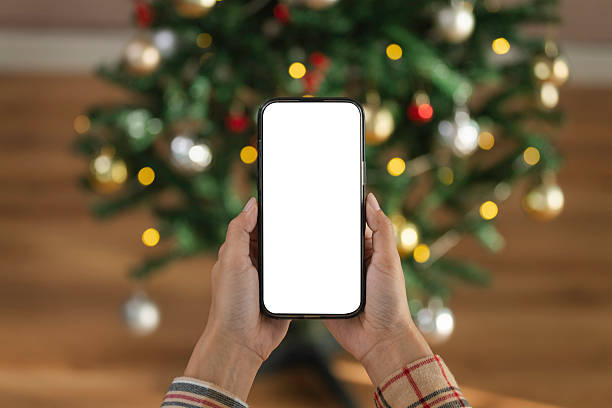 istock Smartphone screen mockup in hand showcased against festive Christmas lights to emphasize digital holiday marketing mobile app promotion and seasonal online engagement 2248556926