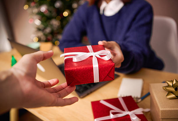 istock Christmas gift exchange with red present box and hands giving in warm festive atmosphere inspiring holiday celebration gratitude generosity and joyful seasonal connection concept 2248556937