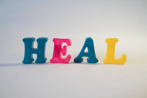 Colorful Plastic Letters Spelling HEAL on White Background