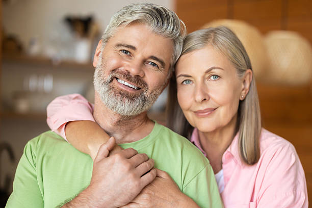 istock Smiling elderly couple embracing and looking at camera 2248557732