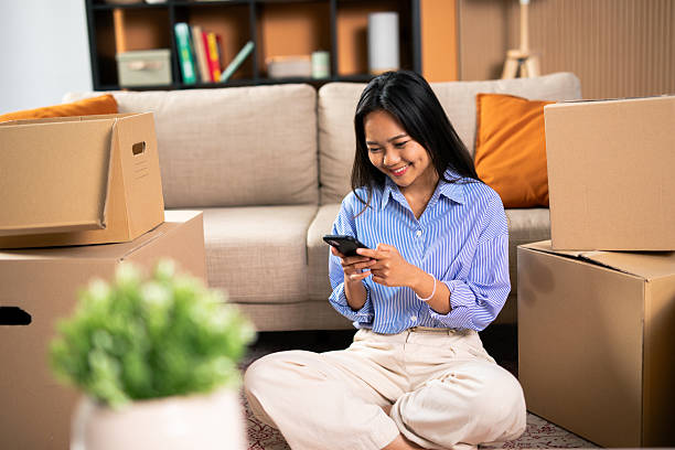 istock Young asian woman sitting on floor using smartphone during relocation 2248559213