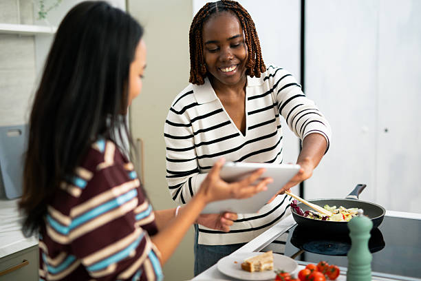 istock Friends cooking healthy meal together using digital tablet 2248559439