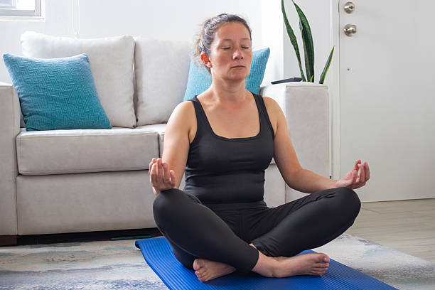 istock Woman meditating in lotus position practicing mindfulness at home 2248560345