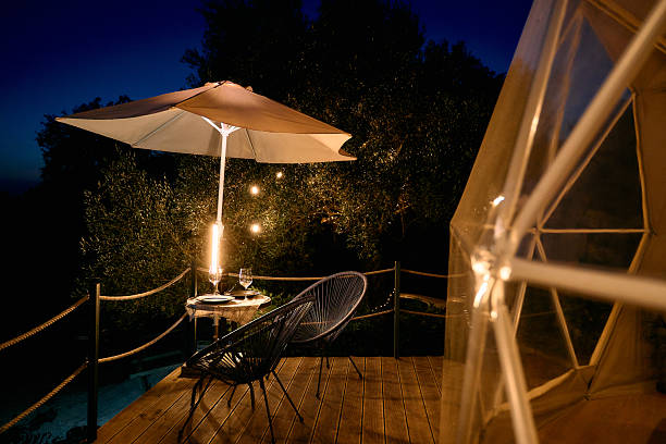 istock A Serene Evening Retreat: Cozy Outdoor Seating with Umbrella, Lanterns, and a Poolside View Under a Starry Night Sky 2248560570