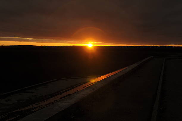 the setting sun between the dark sky and the earth