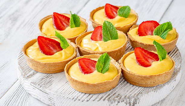istock Mini mango cream tarts with strawberry and mint on white wooden board 2248563124