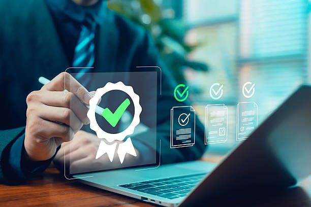 istock Business person using a digital pen to approve a certification badge and verified documents on a laptop, symbolizing quality assurance, compliance, validation, and professional digital workflow 2248563486