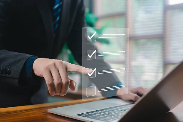 istock Business person tapping a digital checklist interface above a laptop, representing task management, productivity, workflow optimization, modern technology solutions in professional work environments. 2248563493