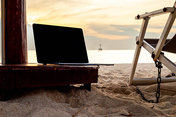istock Digital nomad work place. Laptop on a beach sea coast at sunset. 2248563530
