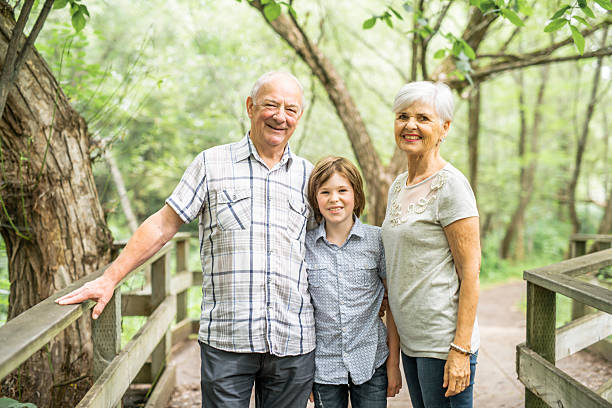 istock Grandparents with grandkid on summer forest having great time 2248566102