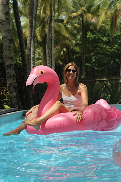 istock Woman floating on flmaingo in the pool 2248566178