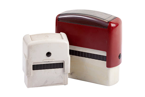 A wooden stamp stands on closed file folders. The folders are used. The background is white with space for text.