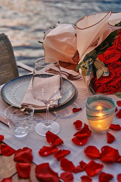 istock An Elegant Dining Experience by the Water with Romantic Decor Featuring Roses, Candlelight, and Petals Setting a Perfect Ambiance for Love 2248567238