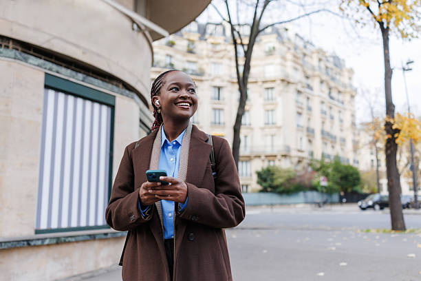 istock Young woman standing outdoors with smartphone 2248571046
