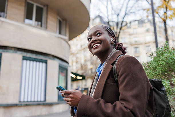 istock Young woman smiling outdoors with phone 2248571056