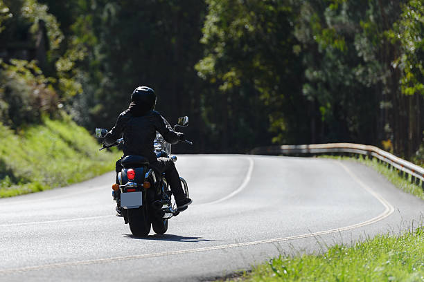 istock biker on a custom classic motorcycle rides down the road, road traffic 2248573990