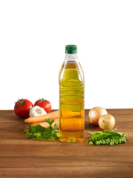 Olive oil bottle with fresh vegetables  on a wooden table with clipping path