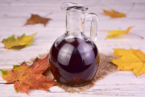istock Bottle with maple syrup and maple leaf on white wooden background. 2248575660