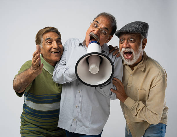 istock Male friends announcing over megaphone on white background 2248576275