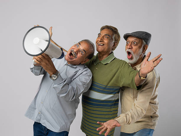 istock Male friends announcing over megaphone on white background 2248576599
