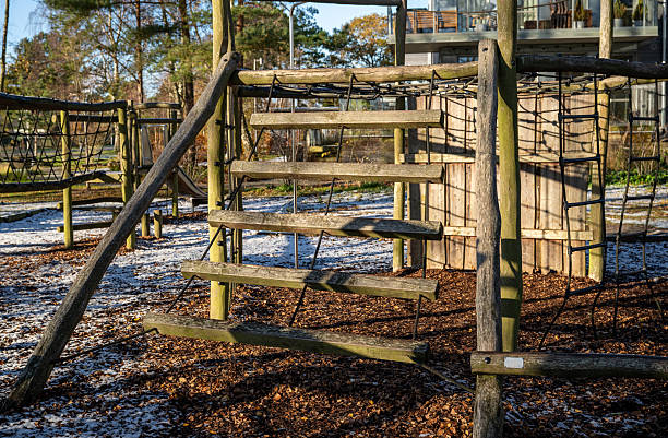 wooden outdoor playground with climbing structures in winter light