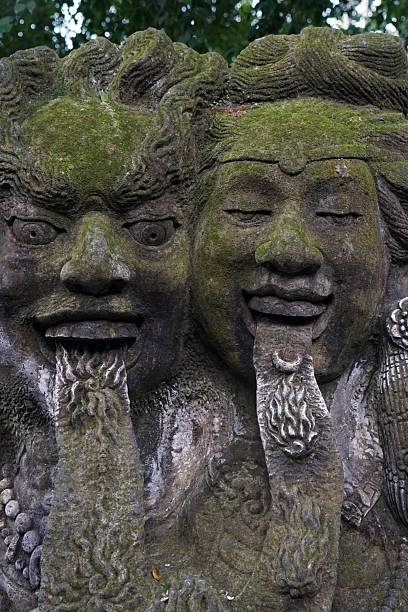 Tropical jungle. Antique stone shrine or a statue portraying a god or a deity. Bali, Indonesia