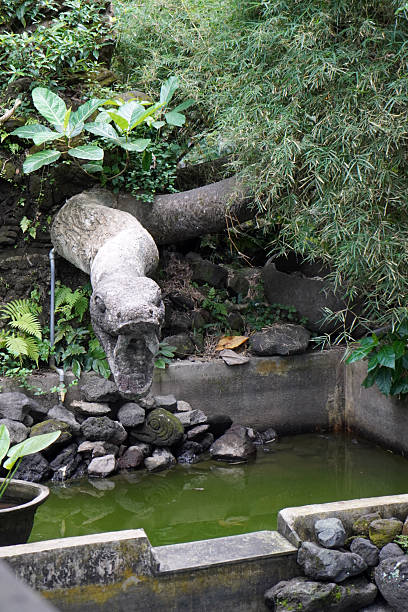 istock Stone statue of a snake by a pond 2248580497