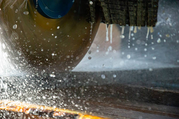 istock A large circular saw is actively cutting wood while water sprays around it, creating a dynamic scene in a busy workshop during the afternoon 2248580817