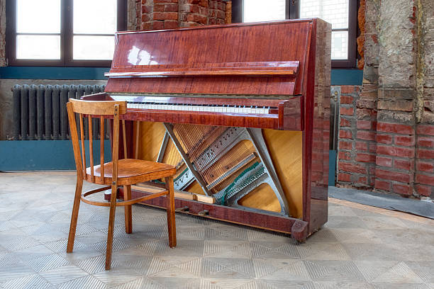 istock A piano with a stool against a backdrop of red brick walls. 2248581496