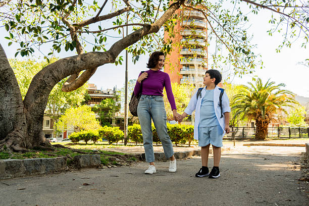 istock Mother and son talking while walking through city 2248582604