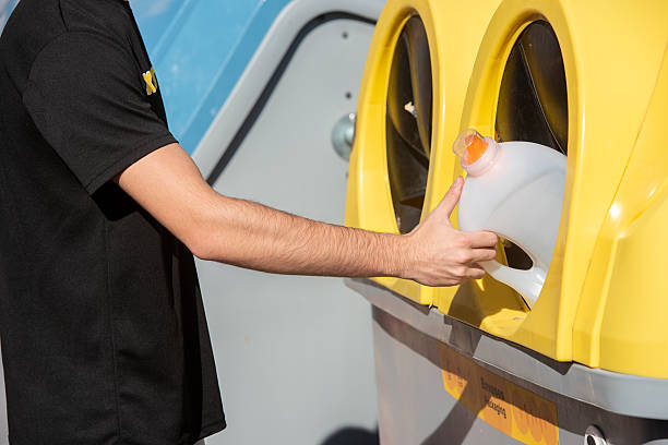 istock Young adult male placing empty plastic bottle into recycling bin 2248583009