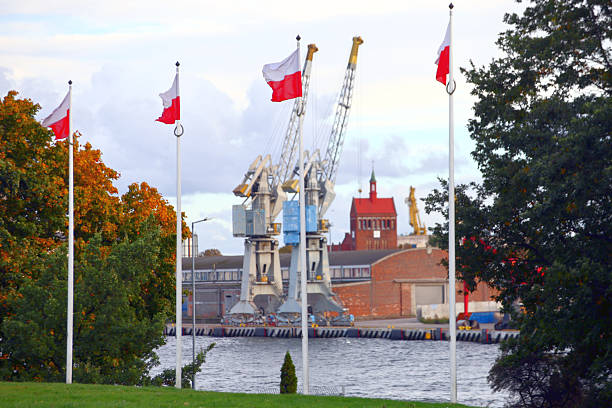 Polish Flags Waving by a Waterfront Industrial Port