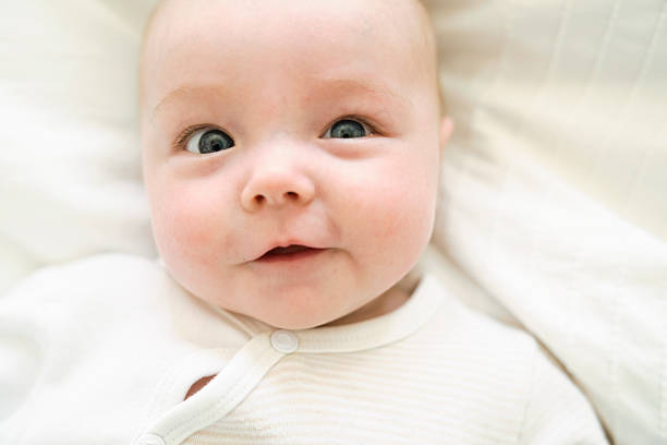 A cute two month old baby in bed at home
