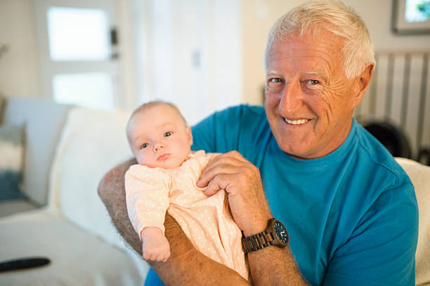 A Grandfather on the sofa with baby at home