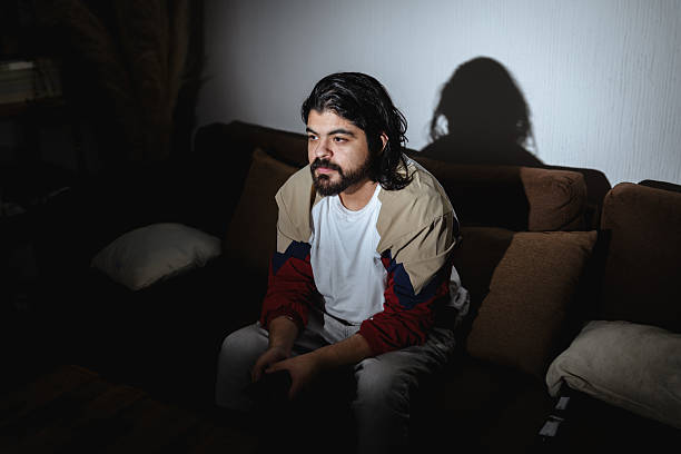 istock Man Watching TV in Dark Living Room with Dramatic TV Light 2248587671